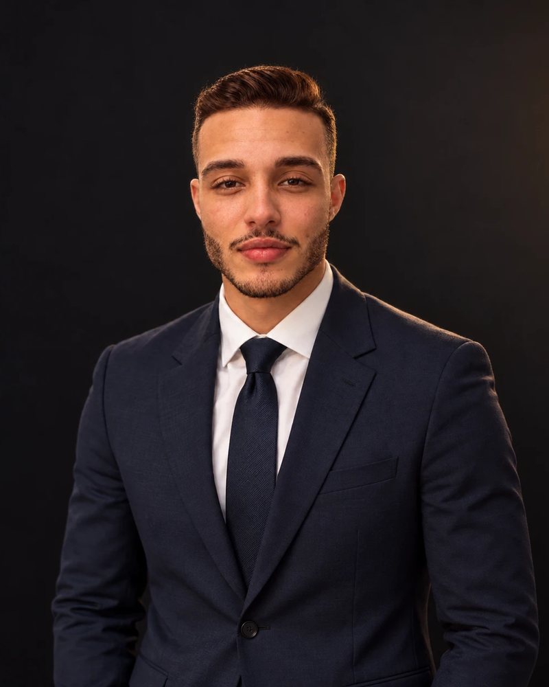 Vitor Afonso, founder and CEO of Mount Olympus AI, in a navy suit against a dark studio background
